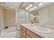 Bright bathroom featuring a dual-sink vanity, tub, and neutral tile surround at 17225 Lark Water Ln # C, Parker, CO 80134