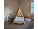 Cozy bedroom with a play teepee, rocking chair, and window with patterned curtains at 17421 E Grand Ave, Aurora, CO 80015