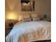 Cozy bedroom features a comfortable bed, bedside tables with lamps, and decorative wall art at 17421 E Grand Ave, Aurora, CO 80015