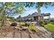 Landscaped backyard features a stone patio, outdoor seating, a grill, and lush greenery at 3080 Big Bear Dr, Sedalia, CO 80135
