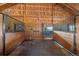 Interior shot of horse stalls with wood paneling and metal bars in a rustic barn setting at 3080 Big Bear Dr, Sedalia, CO 80135