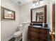 Powder room featuring elegant vanity, decorative mirror, and tiled flooring at 3080 Big Bear Dr, Sedalia, CO 80135