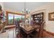 Elegant dining room with marble table, chandelier lighting, and beautiful views from the large window at 3080 Big Bear Dr, Sedalia, CO 80135