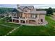 Stunning home featuring a spacious balcony, stone accents, hot tub, and lush lawn at 3080 Big Bear Dr, Sedalia, CO 80135