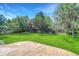 Large, well-maintained backyard featuring lush green grass, mature trees, and a stone patio at 1920 E 145Th Ave, Thornton, CO 80602