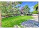 Spacious backyard with a large grassy area, mature trees, and a wood fence surrounding the property at 1920 E 145Th Ave, Thornton, CO 80602