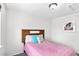 Bedroom featuring a wooden headboard and a pink bedspread with decorative pillows at 1920 E 145Th Ave, Thornton, CO 80602