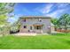 Rear exterior view of a two-story home featuring a well-maintained lawn and a concrete patio at 1920 E 145Th Ave, Thornton, CO 80602