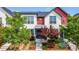 Charming two-story home with vibrant red and white exterior and beautifully landscaped front yard at 5744 Alton St, Denver, CO 80238