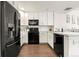 Clean kitchen with white cabinets, modern black appliances, and light countertops at 5744 Alton St, Denver, CO 80238