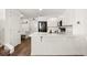 Bright kitchen with white cabinets, modern appliances, and a breakfast bar for casual dining at 5744 Alton St, Denver, CO 80238