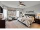 Bright main bedroom featuring hardwood floors, a ceiling fan, and a large window at 7292 Tenby Way, Castle Pines, CO 80108