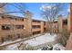 A three-story condo building featuring wood facade and stone accents, with balconies overlooking the courtyard at 4691 S Decatur St # 212, Englewood, CO 80110