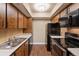 Galley kitchen with warm wood cabinets and stainless steel appliances at 4691 S Decatur St # 212, Englewood, CO 80110