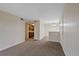 Open living area with carpet flooring leading to the kitchen and dining space at 4691 S Decatur St # 212, Englewood, CO 80110