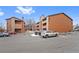 Exterior of condo building with parking lot and snowy patches at 4691 S Decatur St # 212, Englewood, CO 80110