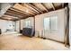 Unfinished basement featuring white insulation with windows and an exposed ceiling at 9882 Harris St, Thornton, CO 80229