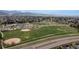 Aerial view of a school and park surrounded by a neighborhood with rolling hills at 9620 W Chatfield Ave # D, Littleton, CO 80128