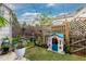 A charming backyard with a small lawn, wooden fence, a fountain, flowers, and a playhouse at 9620 W Chatfield Ave # D, Littleton, CO 80128