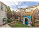 Backyard featuring small playhouse, water fountain and manicured garden at 9620 W Chatfield Ave # D, Littleton, CO 80128