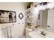 Bathroom with modern vanity, white fixtures, shelving and decorative artwork at 9620 W Chatfield Ave # D, Littleton, CO 80128