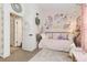 Bedroom featuring neutral carpet, decorative wall art, daybed and pink accents at 9620 W Chatfield Ave # D, Littleton, CO 80128