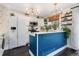 Modern kitchen featuring white cabinets, stainless steel appliances, and a stylish blue kitchen island at 9620 W Chatfield Ave # D, Littleton, CO 80128