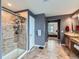Modern bathroom featuring a tiled shower, granite countertop vanity, and a view into the bedroom at 2896 Gemini Loop, Broomfield, CO 80023