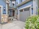 Inviting front entrance with stone accents, cozy porch seating, and a well-maintained two-car garage at 2896 Gemini Loop, Broomfield, CO 80023