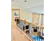 Upstairs hallway with iron and wood railing overlooking the living room with a brick fireplace at 2896 Gemini Loop, Broomfield, CO 80023