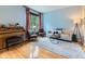 Cozy living room with hardwood floors, a piano, comfortable seating, and bright natural light from the window at 2896 Gemini Loop, Broomfield, CO 80023