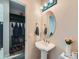 Bright powder room featuring a pedestal sink, decorative lighting, and convenient storage space at 2896 Gemini Loop, Broomfield, CO 80023