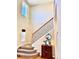 Inviting foyer staircase with decorative iron railing and light-filled windows offers a warm welcome to the home at 2896 Gemini Loop, Broomfield, CO 80023