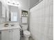 Bathroom featuring white cabinets, tile countertops, and shower with curtain at 5690 W 80Th Pl # 101, Arvada, CO 80003