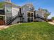 Three story condo building featuring private balconies and outdoor stairwells surrounded by lush lawn at 5690 W 80Th Pl # 101, Arvada, CO 80003