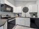 Kitchen features black appliances and white cabinets at 5690 W 80Th Pl # 101, Arvada, CO 80003