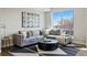 Modern living room features a gray sectional sofa, round black coffee table and abstract wall art at 1919 Eaton St, Lakewood, CO 80214