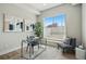 Stylish home office featuring a glass desk, modern art, and a comfortable chair bathed in natural light at 1919 Eaton St, Lakewood, CO 80214