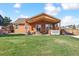 Manicured backyard with covered patio, hot tub, outdoor seating, and lush green lawn at 1294 Kittery St, Castle Rock, CO 80104