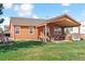 Backyard view with covered patio, hot tub, outdoor seating, and lush green lawn at 1294 Kittery St, Castle Rock, CO 80104