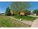 Well-maintained home with a lush front yard, mature trees, landscaping and a two-car garage at 1294 Kittery St, Castle Rock, CO 80104