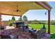 Inviting covered patio with a hot tub, lounge seating, stone flooring, and a picturesque backyard at 1294 Kittery St, Castle Rock, CO 80104