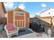Backyard storage shed with grill, wicker chair and beautiful landscaping at 1294 Kittery St, Castle Rock, CO 80104