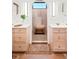Bright bathroom featuring double vanity and tiled walk-in shower with bench seating at 1620 S Ogden St, Denver, CO 80210