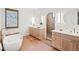 Bright bathroom featuring double vanity, soaking tub and tiled walk-in shower at 1620 S Ogden St, Denver, CO 80210