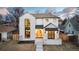 Charming two-story home with a white brick facade, well-manicured lawn, and inviting front entrance with arched doorway at 1620 S Ogden St, Denver, CO 80210