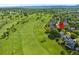 Aerial view of home surrounded by trees and a golf course, with mountains visible in the background at 8040 W 78Th Cir, Arvada, CO 80005