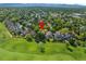 Aerial view of neighborhood with lush green trees, golf course, and mountains in the distance at 8040 W 78Th Cir, Arvada, CO 80005