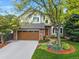 Charming two-story home features lush landscaping, a brick-accented facade, and an attached two-car garage at 8040 W 78Th Cir, Arvada, CO 80005