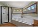 Bathroom featuring corner tub, separate shower, and natural light at 6637 Berry Bush Ln, Evergreen, CO 80439